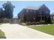 Two-story brick home with attached garage and a long driveway, set on a well-maintained lawn at 1869 Schofield Dr, Hampton, GA 30228