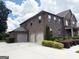 Brick home featuring a spacious driveway and three-car garage and professional landscaping that adds to its charm at 1869 Schofield Dr, Hampton, GA 30228