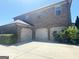Three-car garage attached to a brick home, offering ample parking and storage space at 1869 Schofield Dr, Hampton, GA 30228