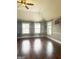 Spacious living room with hardwood floors, ceiling fan, and multiple windows offering plenty of natural light at 1869 Schofield Dr, Hampton, GA 30228