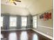 Bright living room features hardwood floors, ceiling fan, and several windows with decorative curtains at 1869 Schofield Dr, Hampton, GA 30228