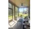 A sunroom with a ceiling fan provides views of the green backyard and patio furniture at 1869 Schofield Dr, Hampton, GA 30228