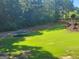 A large, grassy backyard featuring a trampoline and mature trees at 4818 Moon Hollow Ct, Buford, GA 30519