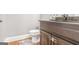 Bathroom featuring a vanity, toilet and light brown cabinets, complemented by a light gray wall at 4818 Moon Hollow Ct, Buford, GA 30519