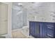 Elegant bathroom featuring a glass-enclosed shower, marble tile, and a blue vanity with gold hardware for a modern touch at 4818 Moon Hollow Ct, Buford, GA 30519