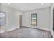 Bright bedroom featuring wood flooring, a window with backyard views, and a bathroom with a glass-enclosed shower at 4818 Moon Hollow Ct, Buford, GA 30519