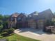 A large brick home with a three-car garage and a well-manicured lawn at 4818 Moon Hollow Ct, Buford, GA 30519