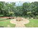 Outdoor fire pit with brick surround and landscaping on well-manicured lawn at 4818 Moon Hollow Ct, Buford, GA 30519