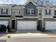 Exterior view of townhomes featuring two-car garages and neutral color palettes at 190 Hampton Cir, Mcdonough, GA 30253