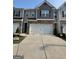 Townhome featuring a two-car garage and a modern exterior design with neutral color palette and brick accents at 190 Hampton Cir, Mcdonough, GA 30253