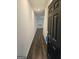 Hallway leading to a room with hardwood floors, and light colored walls with an open black door at 190 Hampton Cir, Mcdonough, GA 30253