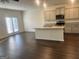 Modern kitchen flows into living area, featuring an island, stainless steel appliances, and hardwood floors at 190 Hampton Cir, Mcdonough, GA 30253