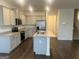 Bright open kitchen boasts granite countertops, island with sink, stainless steel appliances, and hardwood floors at 190 Hampton Cir, Mcdonough, GA 30253