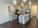 Open kitchen with granite countertops, island, stainless appliances and hardwood floors at 190 Hampton Cir, Mcdonough, GA 30253