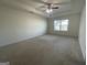 Spacious main bedroom with neutral carpet, tray ceiling, and ceiling fan at 190 Hampton Cir, Mcdonough, GA 30253