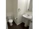 Compact powder room featuring pedestal sink, toilet, and dark hardwood floors at 190 Hampton Cir, Mcdonough, GA 30253