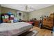 Cluttered bedroom with green walls, hardwood floors, double bed, ceiling fan, and natural light at 349 Campground Rd, Mcdonough, GA 30253