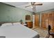Bedroom with green walls, hardwood floors, double bed, ceiling fan, and a closet with paneled doors at 349 Campground Rd, Mcdonough, GA 30253