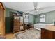 Bedroom featuring green walls, hardwood floors, and a double bed with a ceiling fan overhead at 349 Campground Rd, Mcdonough, GA 30253