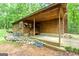 Exterior back of the log cabin home featuring covered porch and stone accents at 349 Campground Rd, Mcdonough, GA 30253