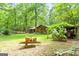 Backyard view of log cabin home featuring large trees and storage shed at 349 Campground Rd, Mcdonough, GA 30253