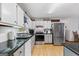 Well-lit kitchen with stainless steel appliances, white cabinets and black countertops at 349 Campground Rd, Mcdonough, GA 30253