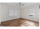Light-filled bedroom with hardwood floors, a ceiling fan and two windows at 397 Campground Rd, Mcdonough, GA 30253