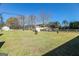 Sprawling backyard with a swing set, storage shed, and mature trees on a sunny day at 387 Colvin Dr, Locust Grove, GA 30248