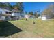 Expansive backyard featuring a covered porch, swing set, shed, and mature trees at 387 Colvin Dr, Locust Grove, GA 30248
