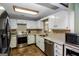 Well-lit kitchen featuring white cabinets, stainless steel appliances, and neutral countertops at 387 Colvin Dr, Locust Grove, GA 30248