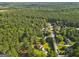 Overhead view of a home in a wooded neighborhood with lush greenery and mature trees at 75 Auburn Rd, Auburn, GA 30011