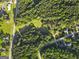 An aerial view shows a home surrounded by lush greenery in a serene, wooded setting at 75 Auburn Rd, Auburn, GA 30011