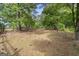 A wooded lot with scattered pine needles and a fenced property line offers privacy at 75 Auburn Rd, Auburn, GA 30011