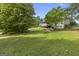 Spacious green backyard featuring a deck, patio and lots of trees offering generous shade at 75 Auburn Rd, Auburn, GA 30011