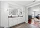 Bathroom vanity with double sinks, granite countertop, white cabinets, and hardwood-style floors at 75 Auburn Rd, Auburn, GA 30011