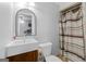 Neutral bathroom featuring modern sink vanity, toilet, framed mirror, and tub-shower with curtain at 75 Auburn Rd, Auburn, GA 30011