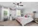 Bright bedroom featuring neutral walls, carpeted floors, ceiling fan, and a built-in desk area by a window at 75 Auburn Rd, Auburn, GA 30011