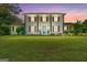 Traditional two-story white home with brown shutters, lush landscaping, and a vibrant blue front door at 75 Auburn Rd, Auburn, GA 30011