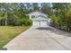 Long driveway leading to a two-car garage on a white house, with a wooden fence and lush greenery at 75 Auburn Rd, Auburn, GA 30011