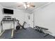 Bright home gym with fitness equipment, ceiling fan, rubber floor, and accessible half-bathroom at 75 Auburn Rd, Auburn, GA 30011
