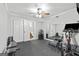 Bright home gym with fitness equipment, ceiling fan, mirrored wall, and accessible half-bathroom at 75 Auburn Rd, Auburn, GA 30011