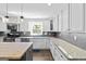 Bright kitchen featuring white cabinets, granite countertops, stainless steel appliances and a gray backsplash at 75 Auburn Rd, Auburn, GA 30011