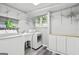 Well-organized laundry room with new washer, dryer, sink, storage cabinets, and wire shelving at 75 Auburn Rd, Auburn, GA 30011