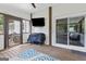 Relaxing screened porch with white brick wall, featuring a TV, grill and outdoor seating at 75 Auburn Rd, Auburn, GA 30011