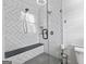 Modern shower with herringbone tile, bench, and glass door at 75 Auburn Rd, Auburn, GA 30011
