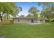 Lush backyard with mature trees and green lawn, showcasing gray painted brick home and patio at 1770 Atherton Dr, Decatur, GA 30035