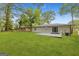 Spacious backyard with lush green lawn, gray painted brick home, and mature trees at 1770 Atherton Dr, Decatur, GA 30035