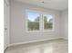 Airy bedroom featuring wood-look flooring, light gray walls, windows for natural light, and modern trim at 1770 Atherton Dr, Decatur, GA 30035