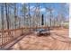 Outdoor deck with dining table, umbrella, and views of the surrounding wooded area at 407 Blue Smoke Trl, Peachtree City, GA 30269