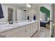 Bathroom with double sinks, vanity, and a mirror. Includes a view into the next bedroom at 407 Blue Smoke Trl, Peachtree City, GA 30269
